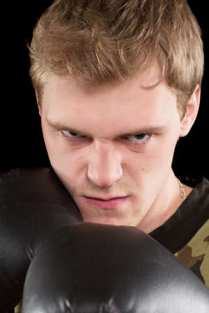 Closeup portrait of angry young man in boxing gloves. Isolatedの写真素材