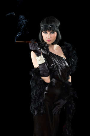 Portrait of young brunette with a cigarette holder dressed in retro style