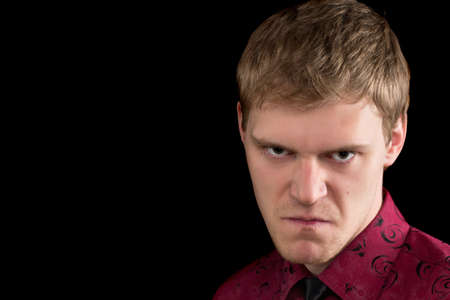 Closeup portrait of angry young man. Isolated