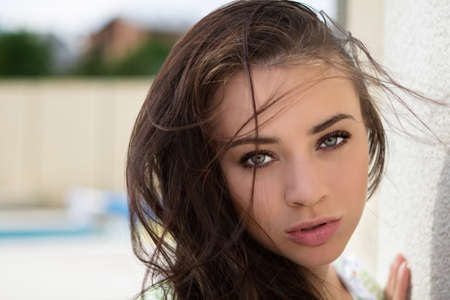 Portrait of flirty young woman posing near the wallの写真素材