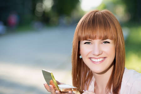Young smiling red-haired woman posing with a powder