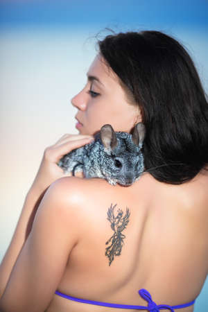 Portrait of young brunette posing with chinchillaの写真素材