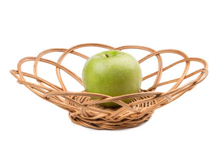 Green apple in wicker. Isolated on whiteの写真素材