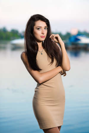 Sexy young brunette posing beige dress outdoorsの写真素材