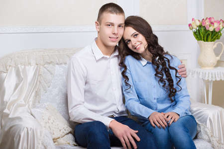 Nice young couple sitting on the sofaの写真素材
