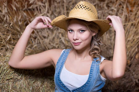 Portrait of young smiling woman posing in straw hatの写真素材