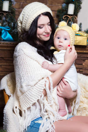 Portrait of young smiling woman holding her babyの写真素材
