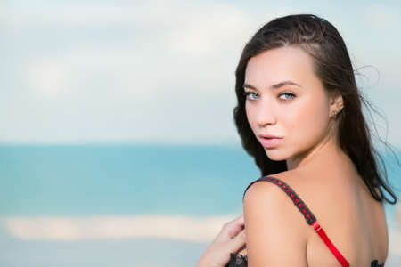 Portrait of sexy young brunette posing on the beachの写真素材