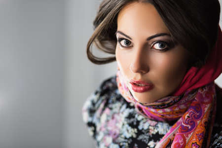 Portrait of young excited brunette in flowered dress and scarfの写真素材