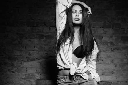 Portrait of sexy brunette posing in bra and shirt. Monochromeの写真素材