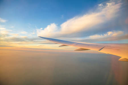 Beautiful view of the sky from the airplane window during sunsetの写真素材