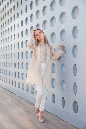 Beautiful young girl dressed in a jacket and jeans posing outdoorsの写真素材