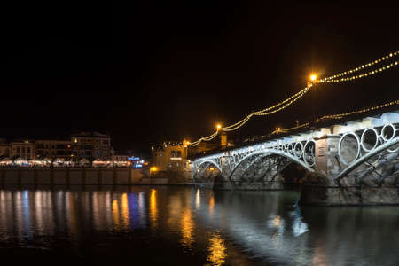 Night illumination of the beautiful Triana bridge in the city of Seville, Spainのeditorial素材