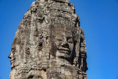 Detail Mural faces in the stone of Bayon belong angkor thom nearly angkor wat is popularity of the site among tourists with blue sky in background. UNESCO World Heritage Site. Siem Reap, Cambodiaのeditorial素材