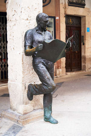Leon, Spain - July 2019: Bronze statue  of man reading a newspaper leaning against a columnのeditorial素材