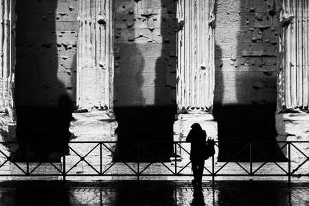 Rome, Italy: Piazza di Pietra, a woman silhouette with the columns of the Temple of Hadrian on the backgroudの写真素材