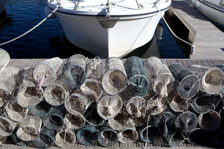 Lobster pots on a quay with boat の写真素材