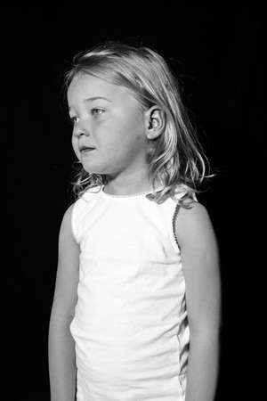 Low key Portrait of a young child. Sad looking girl.の写真素材