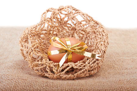 Easter Egg with ribbon on a gunnyの写真素材