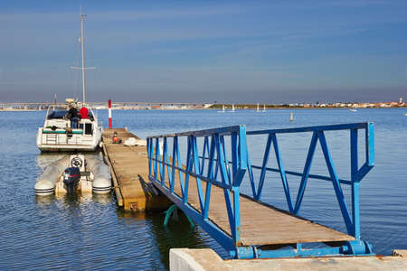 Two men preparing to sail on a yacht in the marinaの写真素材