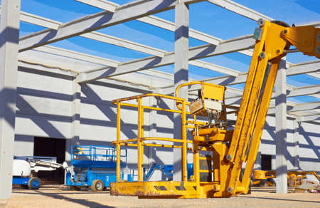 Hydraulic mobile construction platform elevated towards a blue sky の写真素材