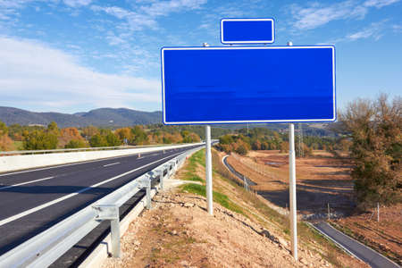 road with sign pole and blue sky with clouds の写真素材