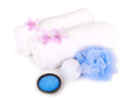 Spa essentials (white towels, salt, bath sponge and aromatic flowers) isolated on white background の写真素材