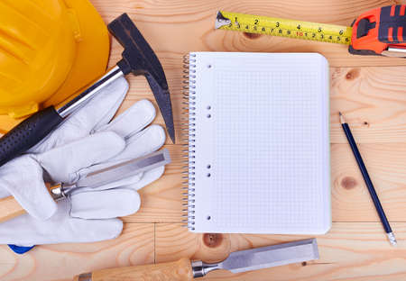 carpentry tools and a piece of notebook on a wooden backgroundの写真素材
