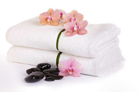 pink orchids and spa stones on white towelsの写真素材