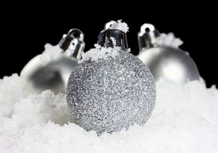 christmas balls with snow in tense light on black background