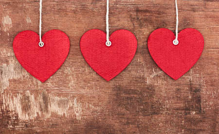 Textile pendent hearts on old shabby wooden backgroundの写真素材