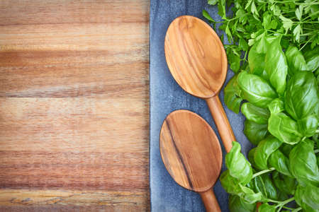 Basil, parsley and wooden spoons, culinary backgroundの写真素材