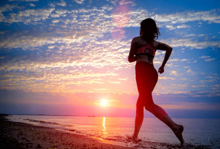Silhouette of woman running on the beach