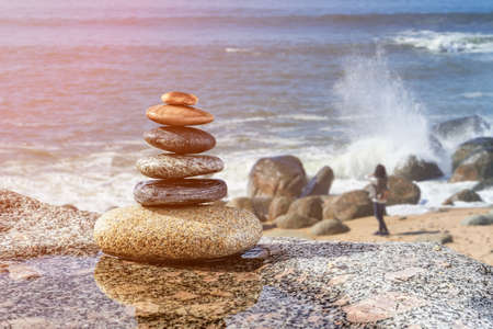 Zen stones on beach, Walking person on backgroundの写真素材