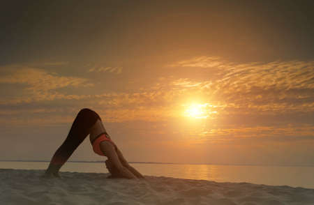 Doing yoga asana at sunriseの写真素材