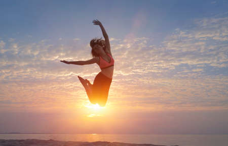 Woman jumping on the beachの写真素材