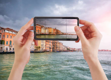 Woman taking photo of Canal Grande and venetian cityscape, Venice, Italy