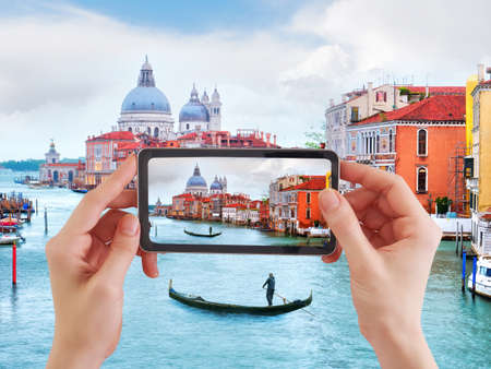 Woman taking photo of Traditional gondola in Venice, basilica Santa Maria della Saluteの写真素材