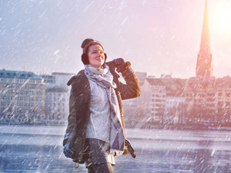 Young beautiful girl enjoying with snowing at Alster Lake in Hamburg cityの写真素材