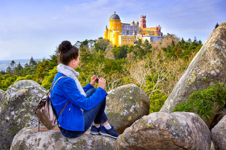 Woman traveler enjoying famous landscape and Palace of Pena, Sintra, Lisboaの写真素材