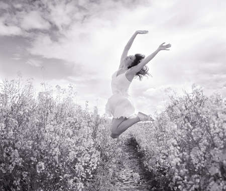 Jumping Woman in yellow field, black and whiteの写真素材