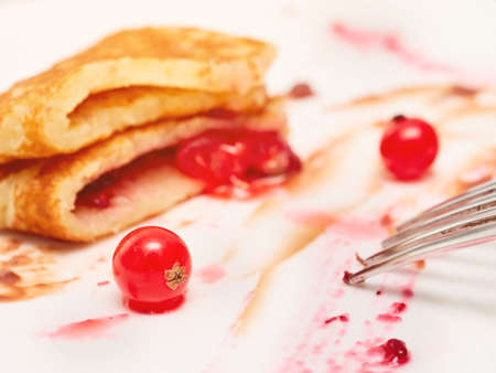 Plate with half-eaten pancakes with berry jamの写真素材