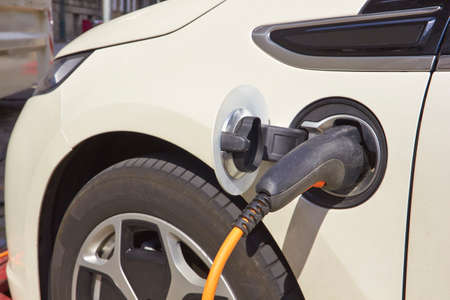Electric Vehicle, charger station with power supply plugged into an electric car being chargedの写真素材