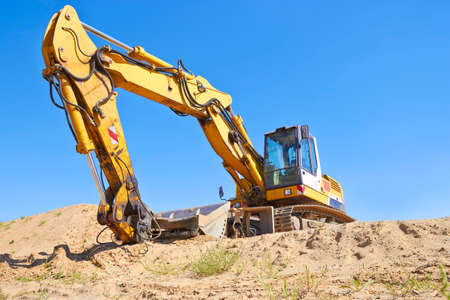 Excavator in construction site against blu skyの写真素材