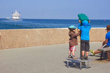 TRAVEMUNDE, GERMANY - JUNE 11, 2013: Children looks on ships in telescopeのeditorial素材