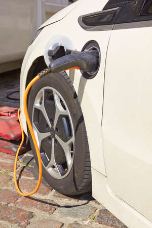 Power supply plugged into electric car.の写真素材