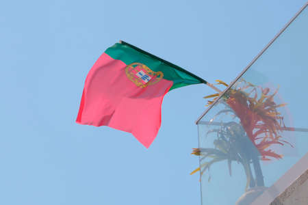 Portugal flag fixed on house balcony and fluttering on windの写真素材