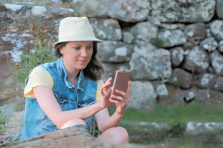 Beautiful caucasian woman in hat using smartphone outdoor
