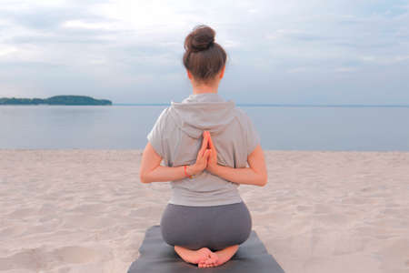 Woman sitting back on Yoga mat and doing yoga stretching exerciseの写真素材