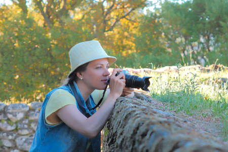 Female photographer working at countryside, shooting photographerの写真素材
